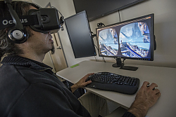 Dr. Ibrahim Dahlstrom-Hakki of LCIRT wears virtual reality headset while computer monitor shows scene that he is viewing