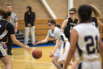Landmark College women's basketball team player dribbling ball.