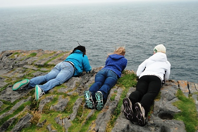 3 Landmark College students looking over the cliffs of Moher.