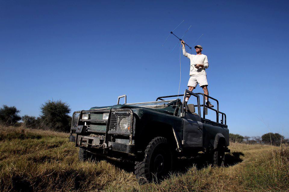 Andrew Stein stands atop an all-terrain vehicle holding a large antenna