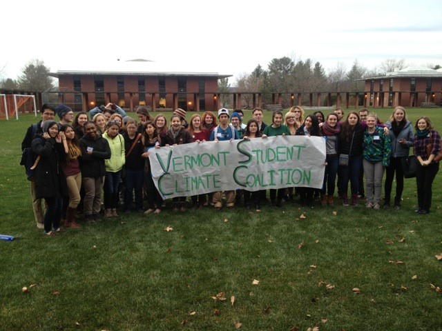 A large group of students stands on the Landmark College campus with a Vermont Student Climate Coalition banner