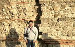 Student standing in front of the Roman Wall in central London