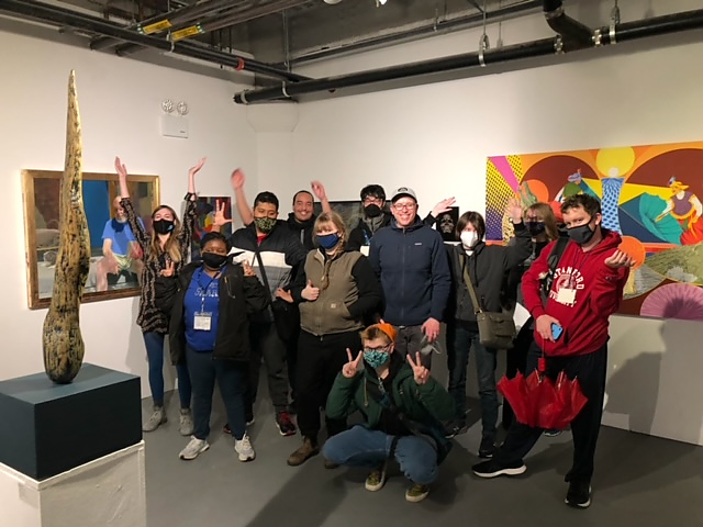 Group shot of students posing with artwork