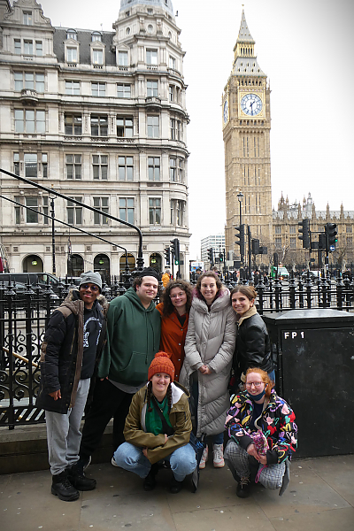 Seven students posing for a photo on a London street with the Big Ben clock tower int he background