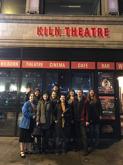 Students on the London 2020 Study Abroad trip pose for a group shot with the marquis of the Kiln Theater