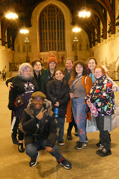Nine students pose for a photo inside Westminster Hall.