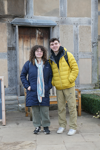 Two students posing for photo outside front door of Shakespeare's house