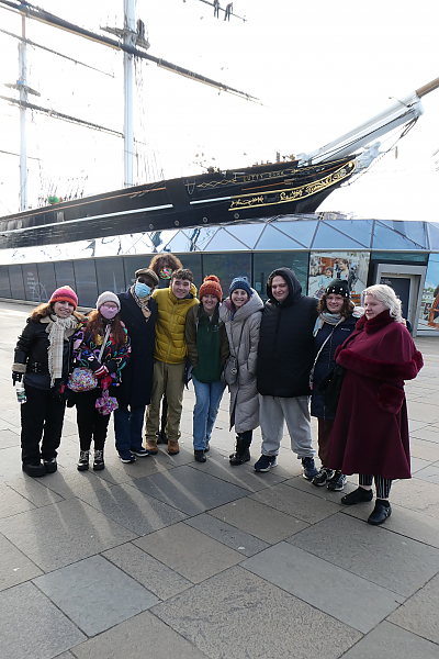 10 members of the London Study Abroad trip pose for photo with the prow of large sailing vessel behind them