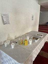 A table set up with bottles of juice and boxes of treats