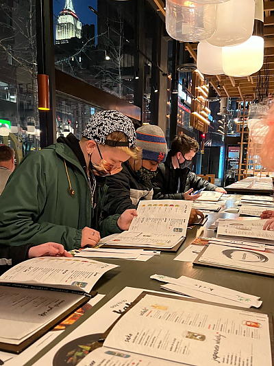 Students in NYC restaurant looking at menus.
