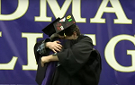 Graduating student Eric Ellman embracing his father Mark Ellman, who is a Landmark College trustee, on the commencement stage.