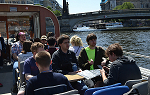 Group of students on study abroad trip to Germany riding in an open air boat on river