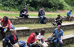 Several students sitting on stone benches on three elevated tiers