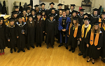 A photo of the Fall 2019 Class wearing their graduation caps and gowns, taken backstage with Landmark College President Dr. Peter Eden just before the December 14, 2019 Commencement Ceremony.