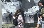 A student on the 2018 summer Study Abroad trip to Germany looks at a photo mural on the wall of the former Gestapo headquarters. 
