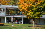 Students in autumn walking past modern STEM building