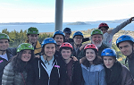 A group photo of the students on the Summer 2018 Study Abroad trip to New Zealand wearing safety helmets during a trip to view the Rotorua crater. 