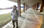 Student Steven Vitt walking under the colonnade on the lower campus.