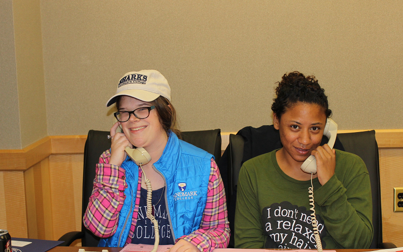 Two Landmark College students talking on phones.