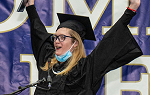 Student raises arms in air as she cheers after receiving degree during December 2021 graduation ceremony. 
