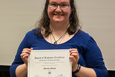 Student Marth Meigs holding the Business and Entrepreneurship Award.