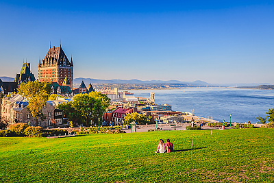 Students sitting on a grassy hillside overlooking Quebec City, Canada