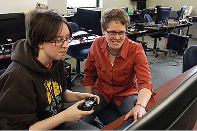 Student and professor in computer lab with game controller and keyboard