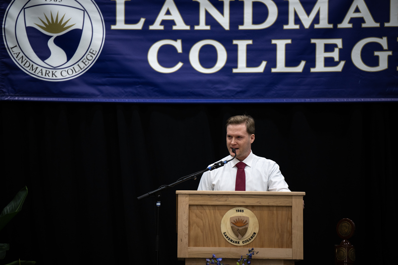 Man wearing white shirt and necktie making remarks at podium