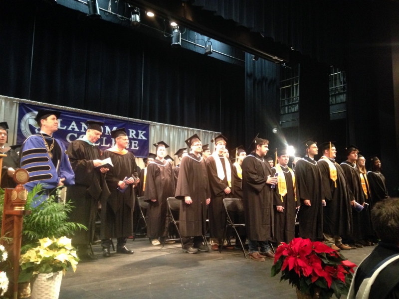 Senior administrators and graduates stand on the stage at the start of the ceremony
