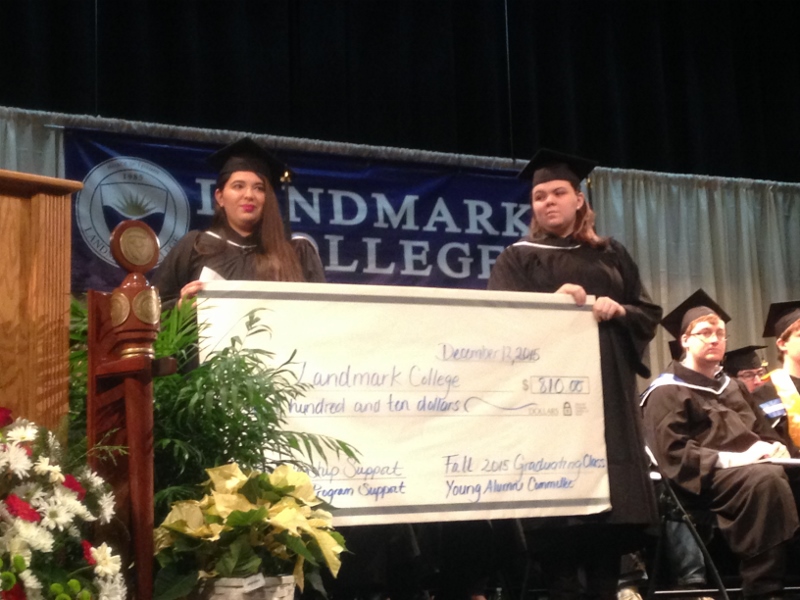 Two students hold an oversized check representing the class gift