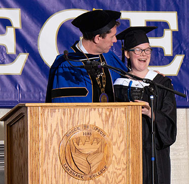 Megan Freeman smiles at the audience after accepting the Charles Drake Award from Landmark College president Dr. Peter Eden during the 2019 Spring Commencement ceremony.