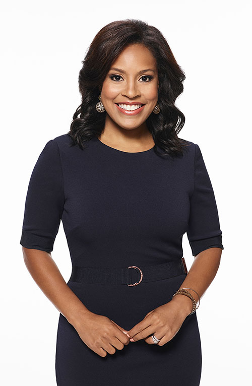 Picture of Sheinelle Jones on white background. She has long dark hair, plum colored dress, and is smiling. 